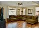 Spacious living room with hardwood floors, large windows, and comfortable sectional sofa at 5705 Petrified Tree Ln, North Las Vegas, NV 89081