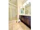 Tiled bathroom featuring a glass shower enclosure, dark cabinets, and a neutral-toned color scheme at 6205 Windy Oaks Ct, Las Vegas, NV 89139