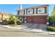 Two-story home featuring a two-car garage, landscaped yard, and a combination of stone and stucco facade at 6205 Windy Oaks Ct, Las Vegas, NV 89139