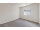 A clean, carpeted bedroom with a window providing natural light and white walls at 6731 Violet Cascade Ave, Las Vegas, NV 89156