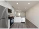 Charming kitchen featuring white cabinets, stainless steel appliances, gray wood-look floors, and recessed lighting at 6731 Violet Cascade Ave, Las Vegas, NV 89156