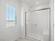 Tiled walk-in shower features glass doors and seating area in a naturally lit bathroom at 6737 Violet Cascade Ave, Las Vegas, NV 89156