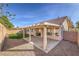 Enclosed backyard featuring a covered patio, gravel landscaping, and a small patch of green grass at 7021 Feather Pine St, Las Vegas, NV 89131