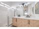 Bright bathroom with double vanity, herringbone cabinets, a shower and updated lighting at 7021 Feather Pine St, Las Vegas, NV 89131