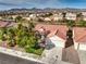 Home exterior featuring a red tile roof, desert landscaping, attached garage, and a well-maintained lawn at 7021 Feather Pine St, Las Vegas, NV 89131