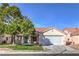 Charming single-story home featuring a 2-car garage, tile roof, mature tree, and well-maintained lawn at 7021 Feather Pine St, Las Vegas, NV 89131