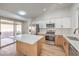 Modern kitchen with white cabinets, stainless steel appliances, and center island leading to backyard at 7021 Feather Pine St, Las Vegas, NV 89131