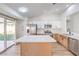 Modern kitchen with white cabinets, stainless steel appliances, and center island leading to backyard at 7021 Feather Pine St, Las Vegas, NV 89131