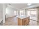 Modern kitchen with bright countertops, island, and sliding door access to outside at 7021 Feather Pine St, Las Vegas, NV 89131