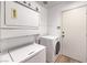 Bright laundry room with stacked washer and dryer and storage at 7021 Feather Pine St, Las Vegas, NV 89131