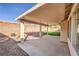 Covered patio with concrete slab, gravel landscaping, and block wall creating a private outdoor space at 7021 Feather Pine St, Las Vegas, NV 89131