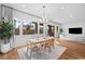 Open-concept dining area with a modern chandelier, large windows, and neutral tones, next to the living room space at 7417 Deschutes Cir, Las Vegas, NV 89129