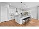 Beautiful kitchen with large center island, pendant lighting, stainless appliances, white cabinetry and hardwood floors at 7417 Deschutes Cir, Las Vegas, NV 89129