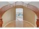 Magnificent foyer showcasing a curved staircase with wood railings, light tile flooring and neutral tones at 7771 Pleasant Slopes Ct, Las Vegas, NV 89131