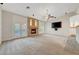 Open living room featuring stone fireplace, ceiling fan, and access to the backyard at 7771 Pleasant Slopes Ct, Las Vegas, NV 89131