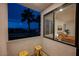 Balcony featuring seating area and views of the bedroom through large sliding windows; palm trees in the background at 800 Loch Katrine Ave, Henderson, NV 89012