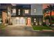 Modern two-story home with a glass garage door, orange front door, and drought-tolerant landscaping at 800 Loch Katrine Ave, Henderson, NV 89012