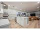 Island kitchen with stainless steel appliances, white cabinetry and countertops open to the living area at 800 Loch Katrine Ave, Henderson, NV 89012