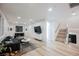 Open living room featuring wood flooring, stairs, a comfortable sectional couch, and a mounted television at 800 Loch Katrine Ave, Henderson, NV 89012
