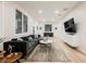Spacious living room with modern decor, hardwood floors, large windows, and a comfortable sectional couch at 800 Loch Katrine Ave, Henderson, NV 89012