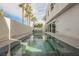 Captivating backyard with an elongated pool surrounded by palm trees and modern architecture, perfect for relaxation at 800 Loch Katrine Ave, Henderson, NV 89012