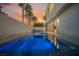Sunset view of a modern backyard with an illuminated pool and spa, perfect for evening relaxation and entertainment at 800 Loch Katrine Ave, Henderson, NV 89012