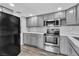 Bright kitchen features gray cabinetry, stone countertops, stainless steel appliances, and wood floors at 808 N Torrey Pines Dr, Las Vegas, NV 89107