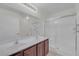 Bathroom featuring double sinks, a large mirror, and a glass-enclosed shower at 9304 Cranesbill Ct, Las Vegas, NV 89149