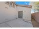 Enclosed back patio with stucco walls, concrete flooring, and sliding glass door at 9304 Cranesbill Ct, Las Vegas, NV 89149