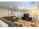 Comfortable living room with a green sectional sofa, floral rug, and modern entertainment center at 937 Spiracle Ave, Henderson, NV 89002