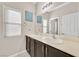 Bright bathroom with a double sink vanity, neutral countertops, and a large mirror at 9413 Aggie Ct, Las Vegas, NV 89148