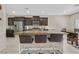 Open kitchen featuring dark wood cabinets, stainless steel appliances, and seating for three at the island at 9413 Aggie Ct, Las Vegas, NV 89148