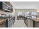 Well-lit kitchen features stainless steel appliances, dark cabinets, and open flow to the dining area at 9413 Aggie Ct, Las Vegas, NV 89148