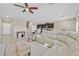 Open living room and kitchen area with tile flooring, an area rug, and a white leather sectional at 9413 Aggie Ct, Las Vegas, NV 89148