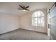 Airy bedroom with a ceiling fan, large arched window providing ample natural light, and plush carpeting at 9882 Pioneer Ave, Las Vegas, NV 89117