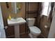 Bathroom features a white pedestal sink, toilet and decorative shelf unit at 10228 W Crepe Myrtle Ct, Las Vegas, NV 89183