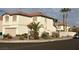 Beige two-story home featuring a red tile roof, desert landscaping, and a two-car garage at 10228 W Crepe Myrtle Ct, Las Vegas, NV 89183