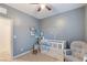Cozy Bedroom with a rocking chair, a crib, and decor shelves on a gray wall at 12382 Piazzo St, Las Vegas, NV 89141