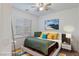 A stylish bedroom featuring a comfortable bed with decorative pillows, a window, and a modern nightstand with a lamp at 12382 Piazzo St, Las Vegas, NV 89141