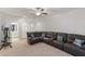 Spacious living room with a sectional sofa, an exercise bike, and neutral-colored carpet at 12382 Piazzo St, Las Vegas, NV 89141
