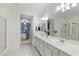 Bright primary bathroom with double vanity, glass-enclosed shower, and view into the bedroom at 12382 Piazzo St, Las Vegas, NV 89141