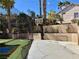 A backyard with a baseball cage, a basketball hoop, and some palms in the distance at 1705 Pink Cliff Ct, Las Vegas, NV 89128