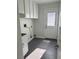 Functional laundry room with modern tile flooring, white cabinetry, and exterior access door at 1705 Pink Cliff Ct, Las Vegas, NV 89128