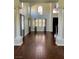 Bright living room showcasing beautiful hardwood floors, large windows, and classic architectural columns at 1705 Pink Cliff Ct, Las Vegas, NV 89128