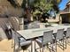 Beautiful outdoor kitchen with a large granite island, built-in grill, and stainless steel refrigerator at 1705 Pink Cliff Ct, Las Vegas, NV 89128