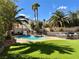 Backyard with artificial turf, mature trees, and a large pool with spa and built in BBQ at 1705 Pink Cliff Ct, Las Vegas, NV 89128