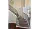 Elegant curved staircase with dark wood floors and wrought iron railings leading to the upper level at 1705 Pink Cliff Ct, Las Vegas, NV 89128