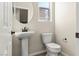 Charming half-bathroom with pedestal sink, modern toilet, and round mirror at 1803 Potosi Peak Ave, North Las Vegas, NV 89031
