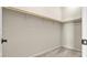 Walk-in closet offers ample storage with wooden rails and neutral walls and carpet at 1803 Potosi Peak Ave, North Las Vegas, NV 89031