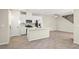 Open-concept kitchen with white cabinets, quartz countertops, stainless appliances, island, and wood-look floors at 1803 Potosi Peak Ave, North Las Vegas, NV 89031